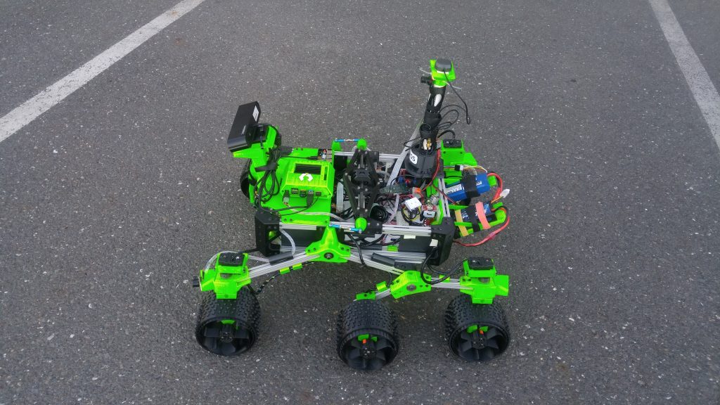 A green 3D-printed rover in the parking lot at CircuitLaunch, Oakland, CA.